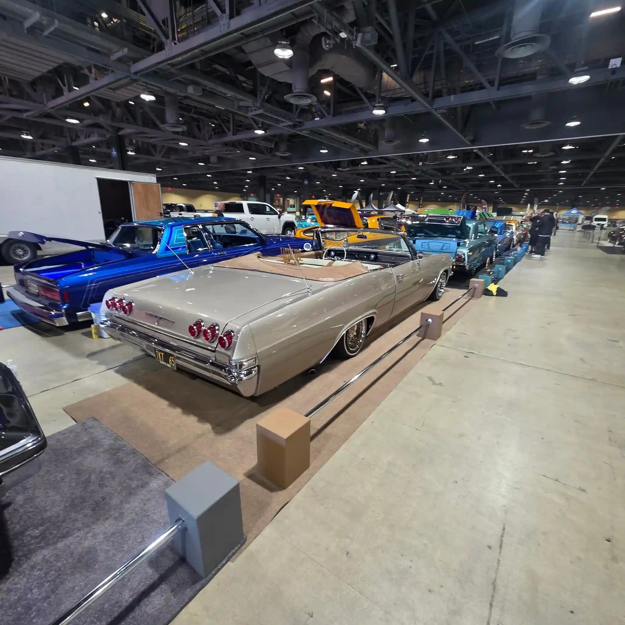 Rear three-quarter view of a classic lowrider on display at the Long Beach Lowrider Super Show